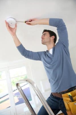 Ultimate Guide To Smoke Alarms 5 Photo Depicting A Qualified Electrician Installing A Fire Alarm